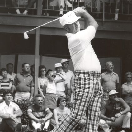 Gibby Gilbert swinging a golf club in front of a large crowd