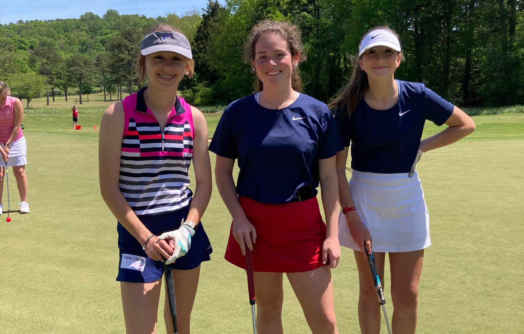 Three Girls Golf teen participants on putting green.